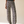 A woman modeling a black short-sleeve top and high-waisted, wide-leg trousers with a black and white abstract pattern, standing against a warm beige studio background.