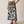 A woman modeling a cream short-sleeve top and a black midi skirt with a large cream floral print, standing against a plain beige studio background.