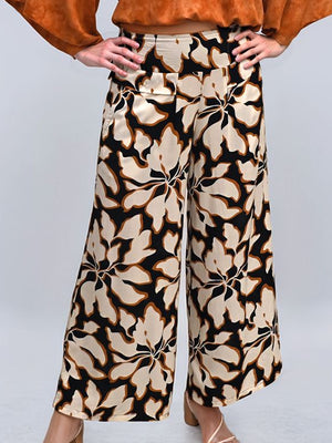 Floral patterned pants worn by a person on a light gray background